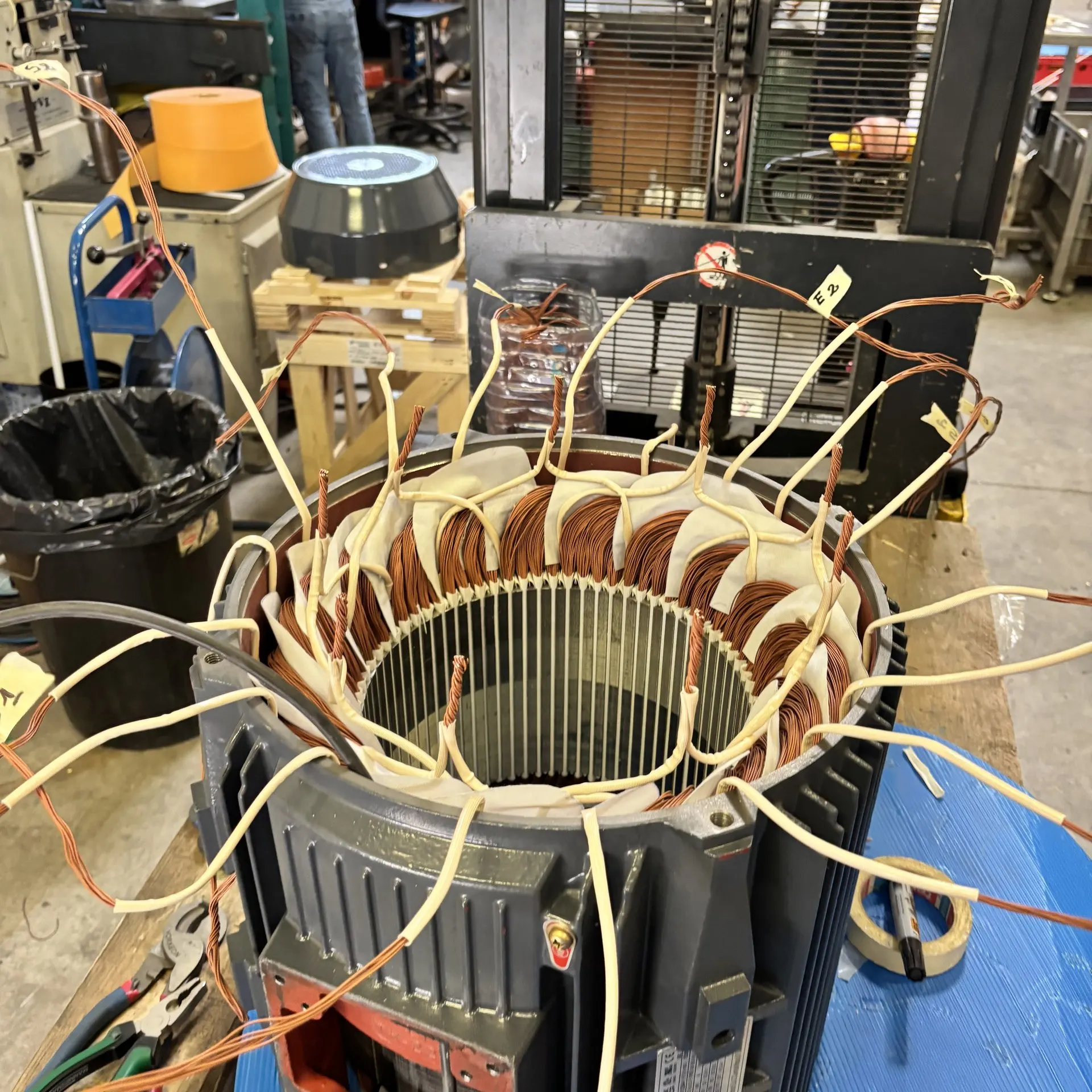 Estátor de motor trifásico con bobinado nuevo en proceso de conexionado de fases, taller Sabadell